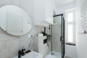 un bagno bianco con lavandino e specchio di Cozy Apartment Malta Lake with Parking - Rentujemy a Poznań Altre 18 foto