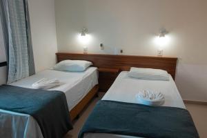 two beds in a room with lights on the wall at Hotel 15 de Julho in Foz do Iguaçu