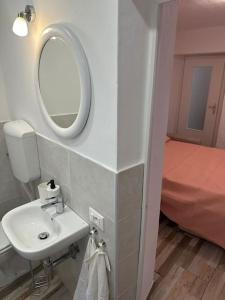 a bathroom with a sink and a mirror and a bed at Appartamento Il Mortaio in Carrara +66 photos