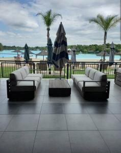 Una sala de estar con sofás y una sombrilla y una piscina. en Olive Luxe at The Blyde, en Pretoria 8 fotos más