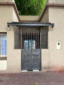 a building with a black door with a gate at Departamento Mis Nonos 4 in Mendoza