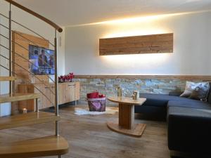 a living room with a blue couch and a table at Pircher-Maes Apart & Stubaital in Telfes im Stubai