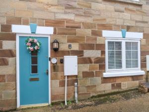a house with a blue door and a window at 1 Johnson's Yard in Guisborough