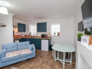 a living room with a blue couch and a table at 1 Johnson's Yard in Guisborough +9 photos