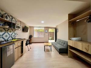 a kitchen and living room with a couch and a table at Económico alojamiento en Medellín por días - A102 By Roots Rentals in Medellín +13 photos