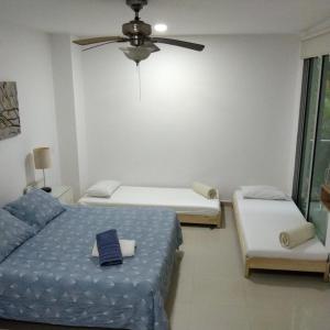 a bedroom with two beds and a ceiling fan at Paraíso Costero Morros Vitri La Boquilla familiar 4 personas in Cartagena de Indias +31 photos