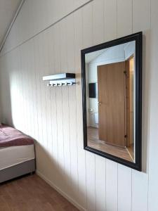 a mirror on the wall of a room with a bedroom at Haugesund City Apartments in Haugesund