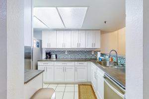 a kitchen with white cabinets and a sink at The Bridges 102 in Mammoth Lakes