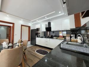 a kitchen with white cabinets and a black counter top at Villa Yara in Djerba