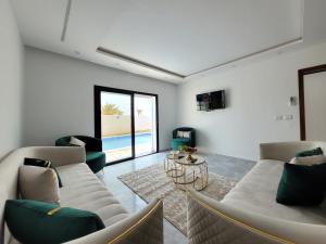 a living room with two couches and a table at Villa Yara in Djerba