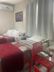 a bedroom with two beds and a table and a chair at Prestige Loft in Petrolina