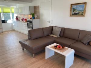ein Wohnzimmer mit einem Sofa und einer Obstschale auf einem Tisch in der Unterkunft Dünenwelle - 3 Zi, Kü, 2 Bäder, Balkon in Binz
