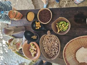 una tavola in legno con ciotole di cibo e altri alimenti di 2 dias e 1 noite no Curupira Amazon lodge a Colônia Paricatuba Altre 37 foto