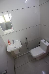 uma casa de banho com um WC branco e um lavatório. em 2 BHK Furnished Flat - 200 m to Guruvayur Temple - For FAMILIES ONLY em Guruvāyūr