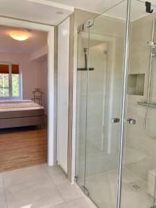 eine Glasdusche in einem Zimmer mit einem Bett in der Unterkunft Dünenwelle - 3 Zi, Kü, 2 Bäder, Balkon in Binz