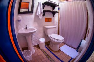 a small bathroom with a toilet and a sink at Hotel Mi Monaco in Pueblo Tapao