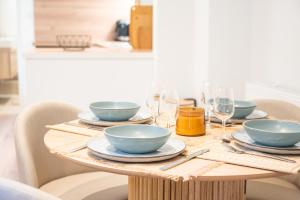 a wooden table with bowls and wine glasses on it at Le haut perché in Colmar