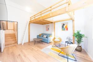 a living room with a blue couch and a staircase at Le haut perché in Colmar