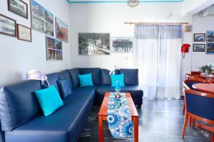ein Wohnzimmer mit einem blauen Sofa und einem Tisch in der Unterkunft Melissani hotel in Sami