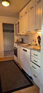 a kitchen with white cabinets and a black rug at House with2 bedroom, bath, sauna, and big yard in Hyvinkää