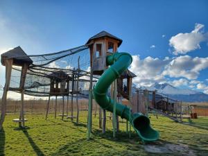 une aire de jeux avec un toboggan vert dans un champ dans l'établissement Apartmán Lomnica Tatragolf I 104, à Veľká Lomnica 43 autres photos