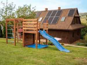 a wooden playground with a slide and a ladder at Beskidzki Zakątek Ustroń - Przytulny domek z balią i kominkiem, idealny na relaks i ucieczkę od miasta in Ustroń