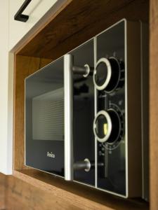 a microwave oven in a wooden cabinet at Beskidzki Zakątek Ustroń - Przytulny domek z kominkiem, idealny na relaks i ucieczkę od miasta in Ustroń +47 photos