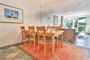 a dining room and living room with a table and chairs at Seeland in Langeoog