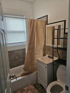 a bathroom with a tub and a sink and a toilet at TKC Homes in Irvington
