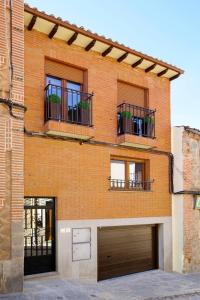 a brick building with three windows and a garage at vallespin 43 parking, wifi in Avila