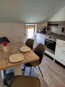 a kitchen with a wooden table with chairs and a dining room at Ferienwohnung Harz in Ballenstedt in Ballenstedt +8 photos