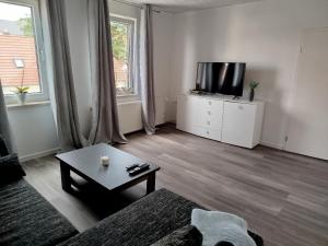 a living room with a tv and a coffee table at Ferienwohnung Harz in Ballenstedt in Ballenstedt