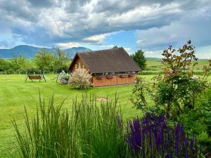 a wooden cabin in a field with a grassy yard at Apartmán Ranč in Martin