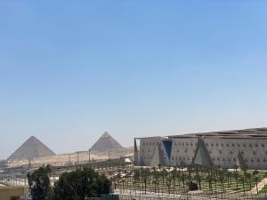 una vista de las pirámides de Giza desde detrás de una valla en gem view guest House, en El Cairo