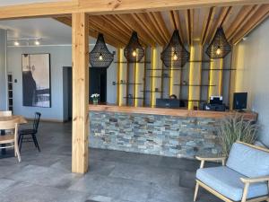 a lobby with a bar with chairs and lights at Hotel Laraquete in Laraquete