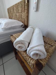 a pile of towels sitting on a basket next to a bed at Loft aconchegante ao lado do Rio Poty Shopping in Teresina