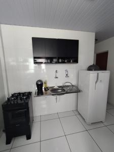 a kitchen with a stove and a sink and a refrigerator at Loft aconchegante ao lado do Rio Poty Shopping in Teresina