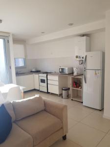 a living room with a couch and a kitchen at Departamento nuevo en el centro in Mar del Plata