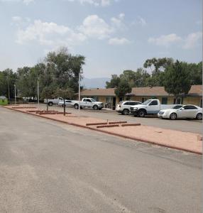 ein Parkplatz mit vor einem Gebäude geparkten Autos in der Unterkunft Ranch Motel in Roswell