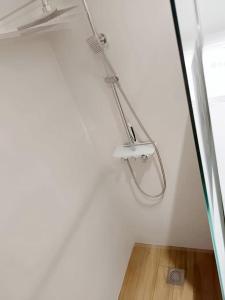 una ducha en una habitación con una pared blanca en Le petit cocon, en Pont-lʼÉvêque 3 fotos más