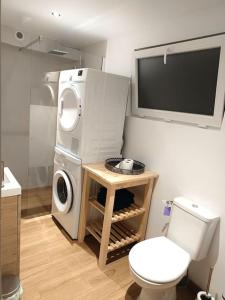 a bathroom with a washing machine and a toilet at Le petit cocon in Pont-lʼÉvêque +3 photos