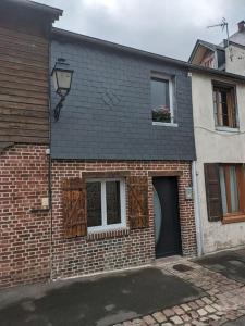 una casa de ladrillo con puerta y ventana en Le petit cocon, en Pont-lʼÉvêque