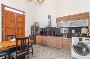 a kitchen with a table and a washing machine at Suite en Centro Historico Terraza, Wifi, Desk, AC in Querétaro
