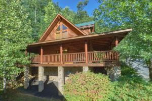 a log home with a wrap around deck at Camp Cozy in Pigeon Forge