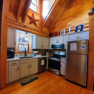 a kitchen with a stainless steel refrigerator and a wooden ceiling at Camp Cozy in Pigeon Forge +25 photos