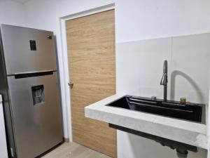 a kitchen with a sink and a refrigerator at Comoda, Confortable Cerca Miraflores Fórum Majadas H10 in El Rodeo +21 photos