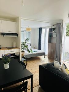 a living room with a couch and a table at Agréable Studio proche Aéroport de Bordeaux in BOD