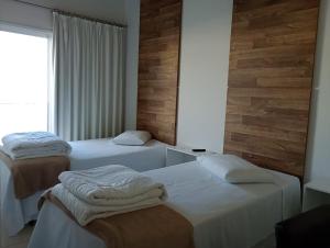 a room with two beds and a window at Hotel Eldorado in Piraí do Sul