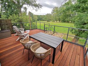 a wooden deck with a table and chairs on it at Ferienwohnung Zur Hohle in Niederreichenbach
