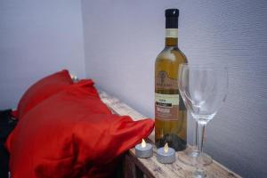 eine Flasche Wein neben zwei Weingläsern in der Unterkunft Sokolov apartments in Tbilisi City + 2 Fotos